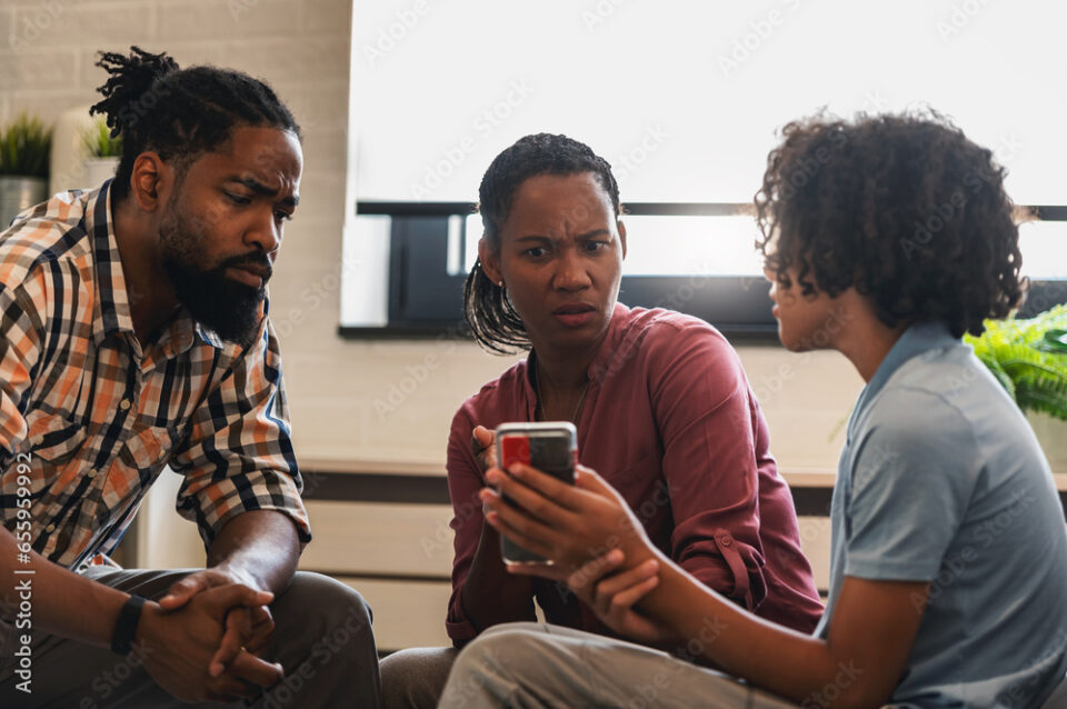 African-American family have a meeting. Parents talking with their teenage son about his smartphone usage. Child internet security. Smartphone and mental health