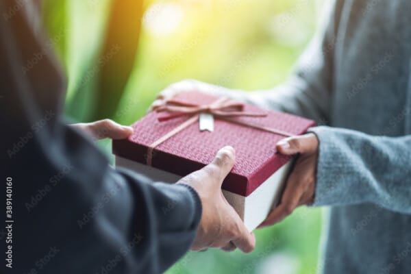 Closeup image of a man giving a woman a gift box