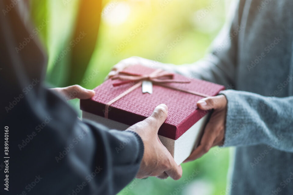 Closeup image of a man giving a woman a gift box