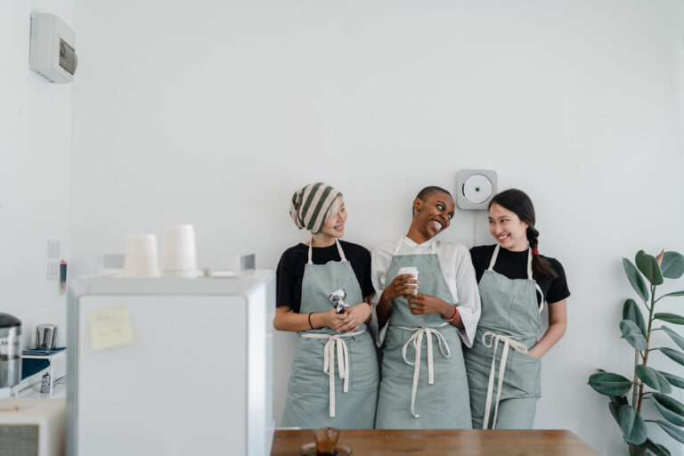 Excited diverse staff of modern coffee house