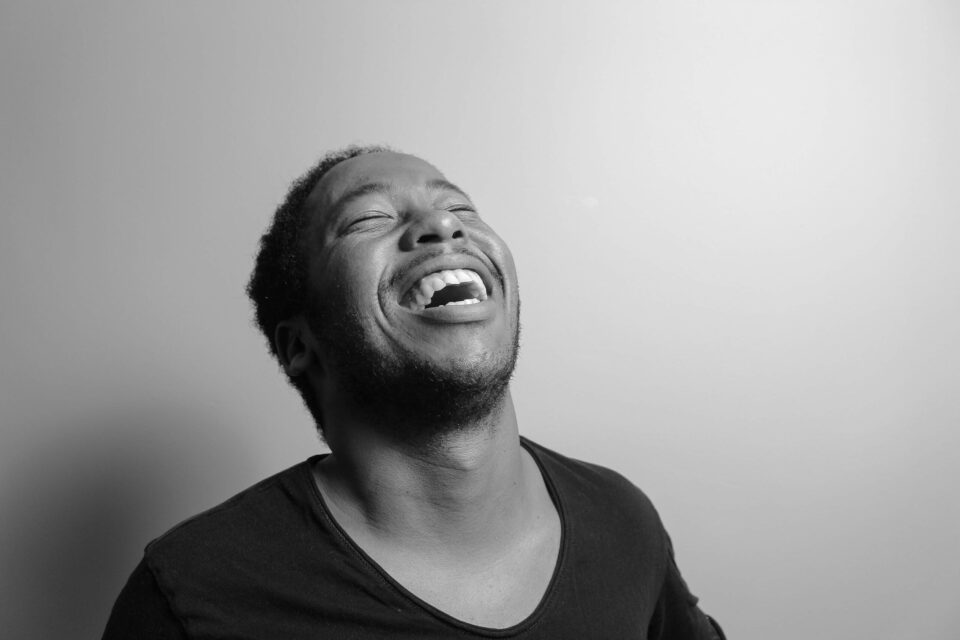 Grayscale photograph of man laughing