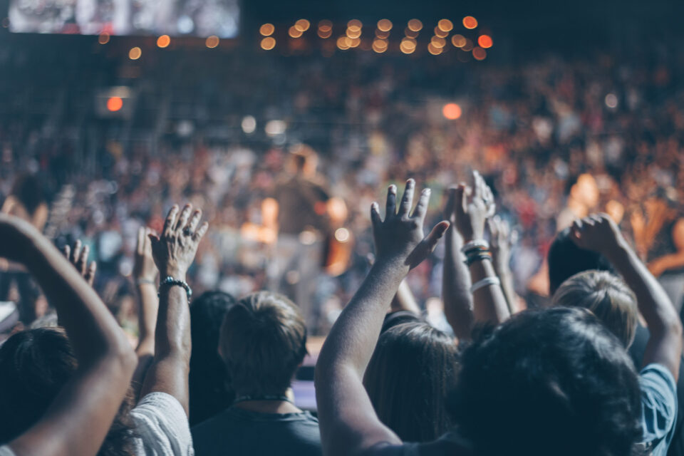 Group of people raise their hands on stadium