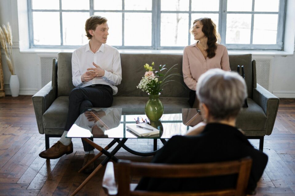 Man in white dress shirt sitting on gray couch