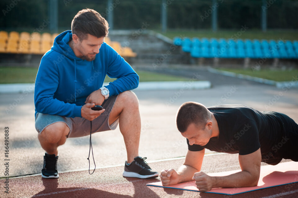 morning plank exercises with personal coach with stopwatch;