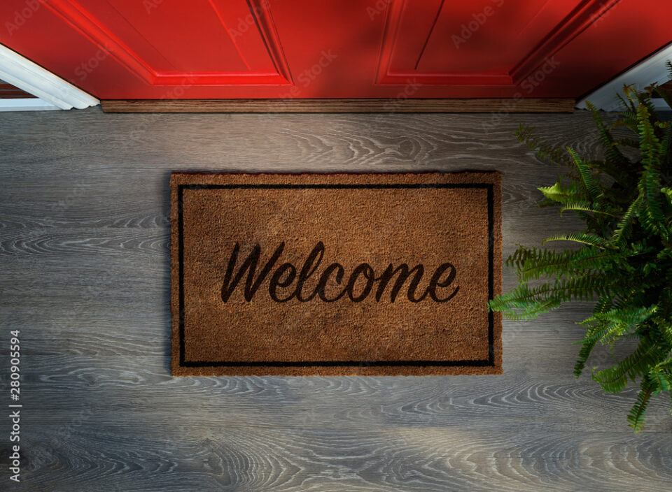 Overhead view of welcome mat outside inviting front door of house