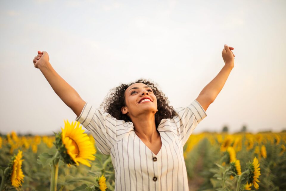 Photo of woman standing on sunflower field