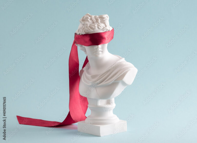 Plaster head with eyes covered red satin ribbon on blue background.