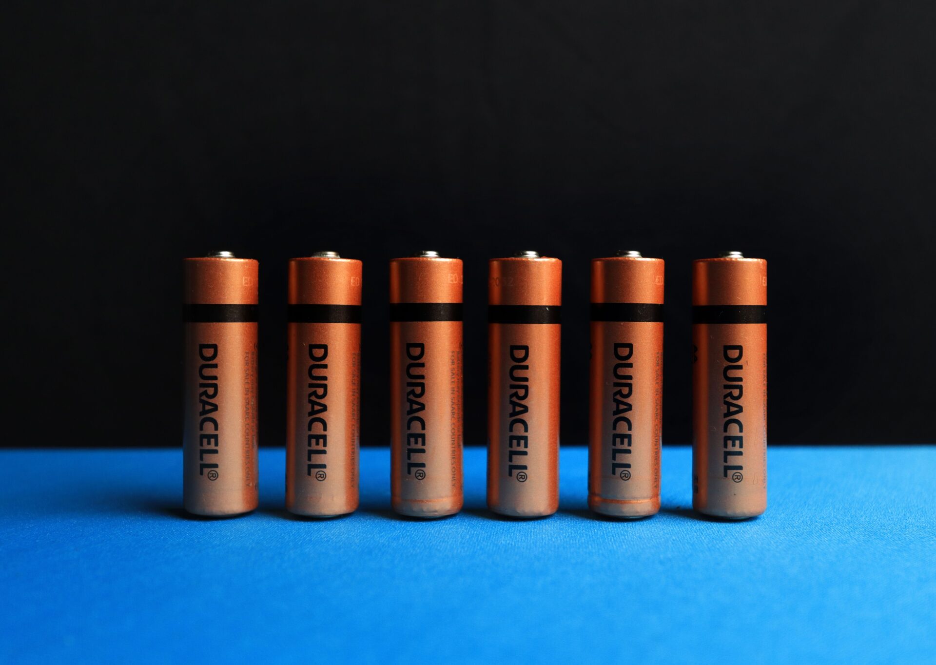 Row of batteries on blue surface