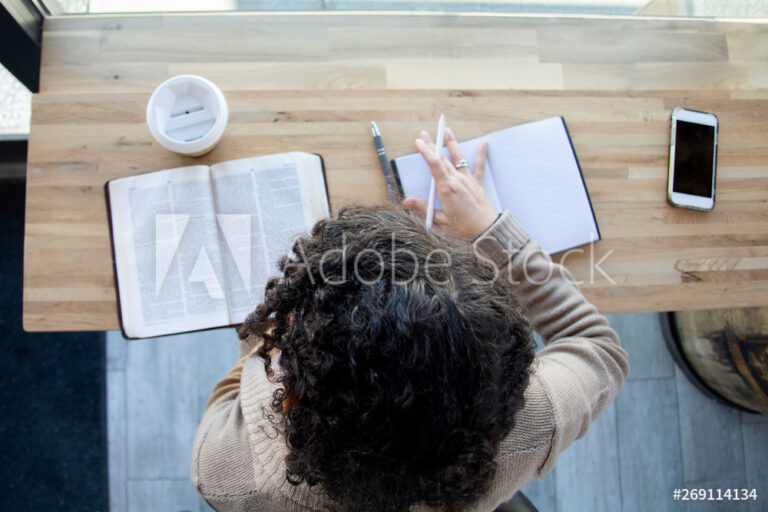 top view of black woman making notes while studying her bible