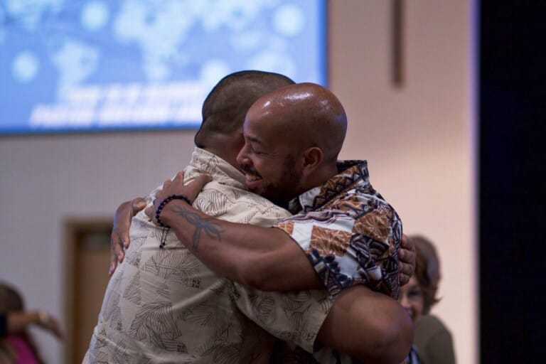 Two men hugging at church, greeting