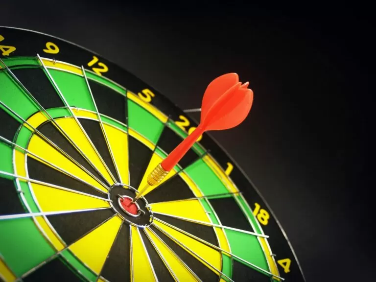 Red and brass dart pin on dartboard