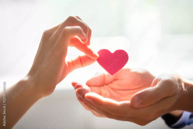 Woman Giving Heart On Man's Hand